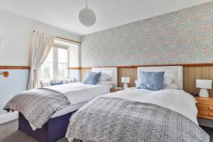 克拉珀姆Swallows Nest Bed and Breakfast的卧室设有两张床铺和蓝色的墙壁