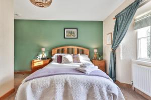 克拉珀姆Swallows Nest Bed and Breakfast的一间卧室设有一张床和绿色的墙壁