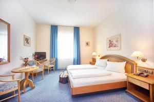 埃塔尔鲁维格德巴耶可罗斯特酒店的酒店客房带一张床、一张桌子和椅子