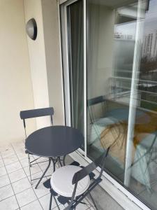 谢勒Spacieux studio sans vis à vis的阳台配有一张桌子和两把椅子