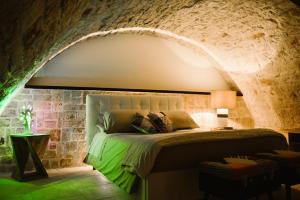 卡斯特拉纳格罗泰Apulia Suite的卧室配有一张石墙床