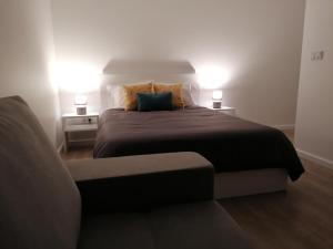 CalhetasRefúgio do Norte的一间卧室配有一张带两盏灯的床和一张沙发。