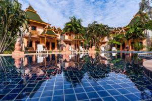 象岛Coconut Beach Resort, Koh Chang的一个带椅子和树木的度假村游泳池