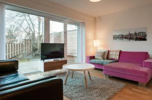 Sollentunatownhouse on Arlanda Stockholm metro line - easy checkin的客厅配有紫色家具和电视