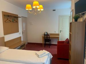 维尔纽斯亚莉克莎老城区酒店的酒店客房配有一张床、一把椅子和一张书桌