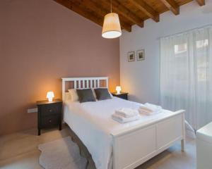卡洛帕尼亚伊奥蒂斯Del Conte的一间卧室配有一张带2个床头柜的大型白色床