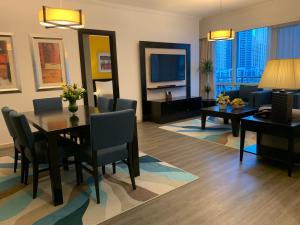 迪拜努然玛丽娜服务公寓的一间带餐桌的客厅和一间带沙发的客厅