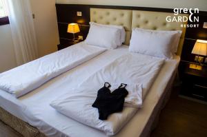 梅斯特GREEN GARDEN Resort - Smart Hotel的一张带两张黑色长袍的床