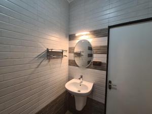 卡兰古特Richard Inn Residency的一间带水槽和镜子的浴室