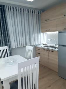 戈里察Shtepi Pushimi Xhoi的厨房配有白色的桌椅和水槽