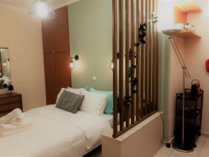 帕特雷Όμορφο Studio στην πόλη Πάτρα的卧室配有白色的床和灯