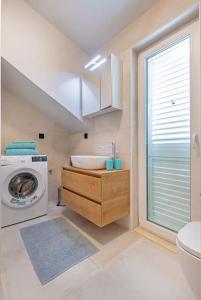 杜布罗夫尼克St Jakov Superior Beach Apartment with Free Parking的一间带水槽和洗衣机的浴室