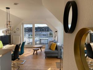 哈里斯莱BEACH HOUSE II - Penthousewohnung in Bestlage mit sonniger Dachterrasse und top Meerblick的客厅配有沙发和椅子