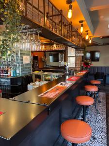 HaleMersey view Hotel & Pub的餐厅内带橘子凳的酒吧
