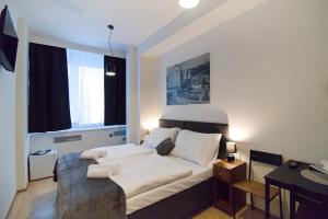 兹林Hotel U Ševce的卧室设有白色的床和大窗户