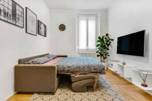 米兰New Milan Central Apartment的一间带床和电视的客厅