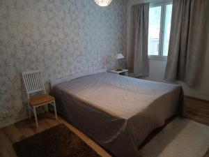 皮耶塔尔萨里FirstHome GuestHouse的卧室配有床、椅子和窗户。