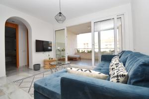 阿尔梅利马Expoholidays - Apartamentos Puerto Almerimar的客厅配有蓝色的沙发和电视