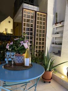 巴里Arco di Levante的一张带一瓶葡萄酒和一些植物的蓝色桌子
