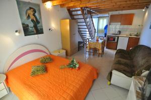 斯达林亚历山德罗酒店的一间带橙色床的卧室和一间厨房