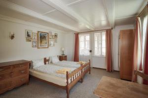 因特拉肯历史城市木屋酒店的一间卧室配有一张床、一个梳妆台和一扇窗户。