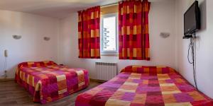 沙托鲁博伊查特斯涛特尔酒店的一间卧室设有两张床、一台电视和一扇窗户。