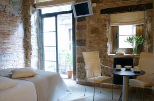 巴塞罗那爱恩B毕加索科尔戴尔公寓式酒店的卧室配有一张床和一张桌子及椅子
