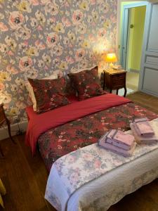 VincellesVilla l'INSOUCIANCE en Champagne的一间卧室配有一张带花卉壁纸的床