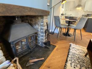 斯卡伯勒Cosy 2 bedroom cottage in Scarborough's Old Town的客厅设有壁炉、桌子和椅子