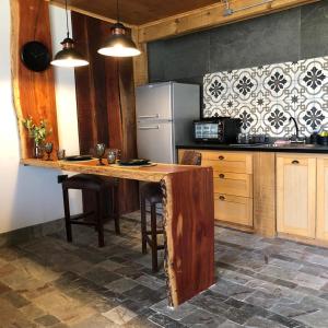 科隆Noha Casa de Campo的厨房配有木桌和冰箱。