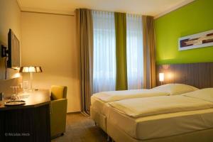 瓦尔多夫阿姆比杨特沃尔德芙酒店的酒店客房设有两张床和绿色的墙壁。