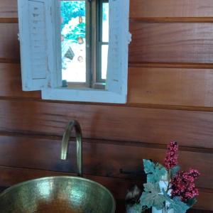 多明戈斯马丁斯Pousada Recanto Viva a Vida的浴室水槽,带窗户和花瓶
