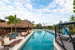 图卢姆Mayan Monkey Tulum的一个带桌椅的度假村游泳池