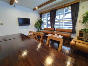 白马村Keimichi Guest House的客厅配有一张大木桌和一张沙发。
