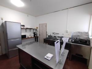 白马村Keimichi Guest House的厨房配有柜台和冰箱。