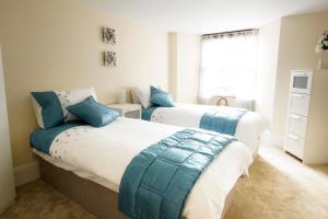 爱丁堡Heritage City - Central New Town Apartment的卧室内的两张床和蓝色枕头