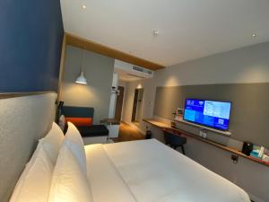 上海上海唐镇智选假日酒店的配有一张床和一台平面电视的酒店客房