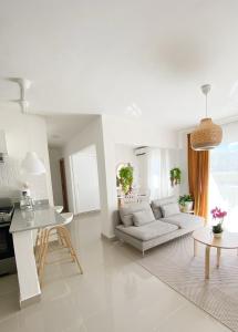蓬塔卡纳OASIS Punta Cana Apartment的白色的客厅配有沙发和桌子