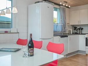 斯凯恩6 person holiday home in Skjern的厨房配有红色椅子和1瓶葡萄酒。