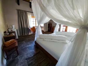 奥乔Sophienhof Lodge的卧室配有一张带白色窗帘的大床