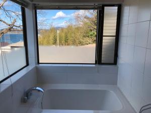 KasaokaShiraishi Island International Villa的带浴缸的浴室和窗户