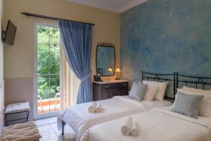 雅典大理石屋酒店的一间卧室设有两张床、镜子和窗户