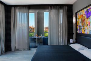罗马21酒店的一间卧室设有一张大床和一个大窗户