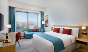 迪拜Avani Ibn Battuta Dubai Hotel的一间设有大床和窗户的酒店客房