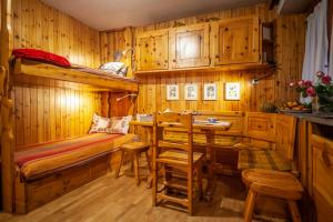 库马约尔Casa-chalet, in centro a Courmayeur!的一间卧室配有一张双层床和一张桌子及椅子。