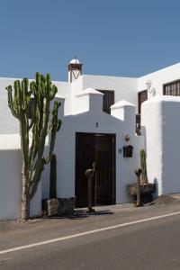 蒂亚斯Las Pérgolas Villa Rural的白色的建筑,有门和仙人掌