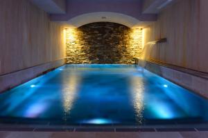 佛罗伦萨维莱苏拉诺酒店的石头墙房中的蓝色游泳池