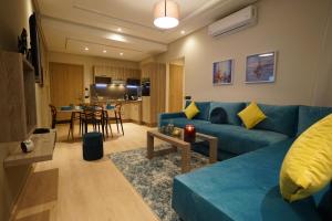 丹吉尔Flamant Rose Appart Hotel的客厅配有蓝色的沙发和桌子