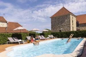 克雷西拉沙佩勒Hotel Les Suites - Domaine de Crécy的两个女人坐在游泳池里