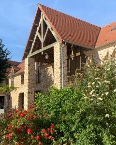 克雷西拉沙佩勒Hotel Les Suites - Domaine de Crécy的一座红色屋顶的石头房子